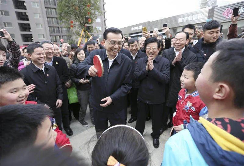 图为李克强在贵阳考察时，一群孩子围住总理“邀约”打乒乓球。